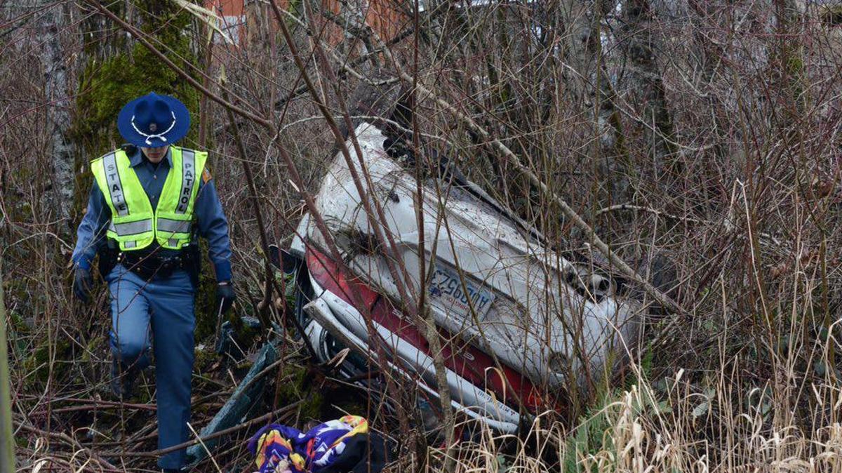 A Washington State Patrol trooper investigates the scene of a rollover crash on Haxton Road north of Boynton on Monday, Jan. 25. A woman believed to be the driver was taken to St. Joseph hospital in Bellingham.