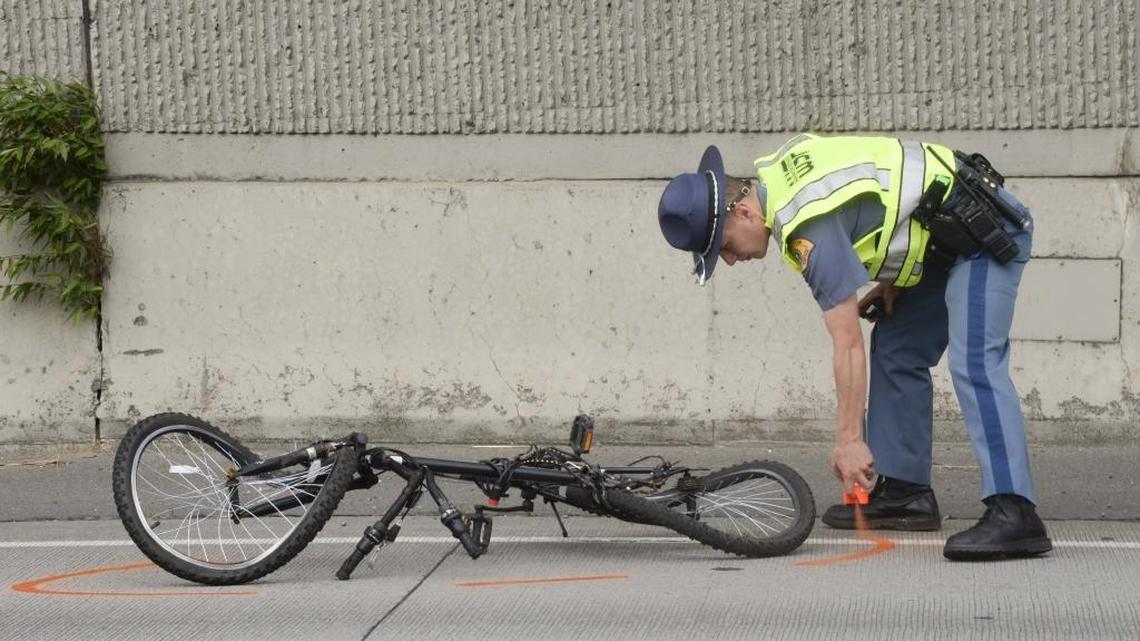 A Washington State Patrol trooper sprays marking paint around a bike that collided with a dump truck on southbound Interstate 5 near Lakeway Drive June 3, 2016. The cyclist, Amanda Carolynn Mihalovits, died June 8 in a Seattle hospital.