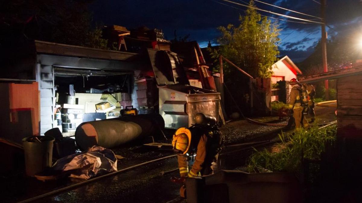 A firefighter with the Bellingham Fire Department rolls up a hose after fighting a blaze in a garage at 2626 Iron St. in Bellingham Monday night, May 2. Officials are still trying to determine the cause of the fire, which didn’t spread to any other buildings.