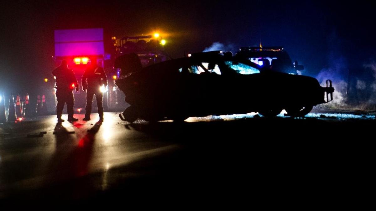 Officers survey the scene of a fatal crash involving a Washington State Patrol trooper’s car and another vehicle on Interstate 5 on Friday, Dec. 18, 2015 near Custer, Wash.