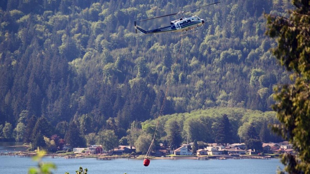 Herald reader Roger Meyers shot this photo of a helicopter picking up water out of Lake Samish on Friday, May 6 to help fight a 10-acre wildfire on Lookout Mountain south of Bellimngham.