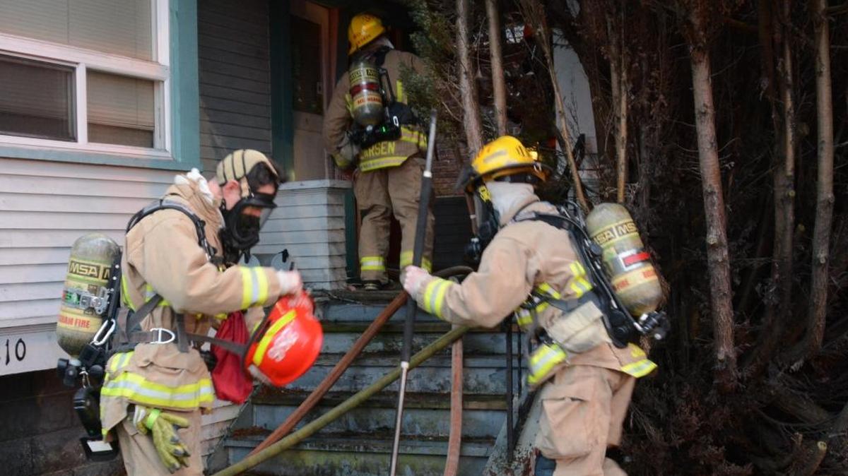 Firefighters prepare to enter a duplex on fire Monday afternoon, Dec. 14, at 1210 Ellis St. in Bellingham.