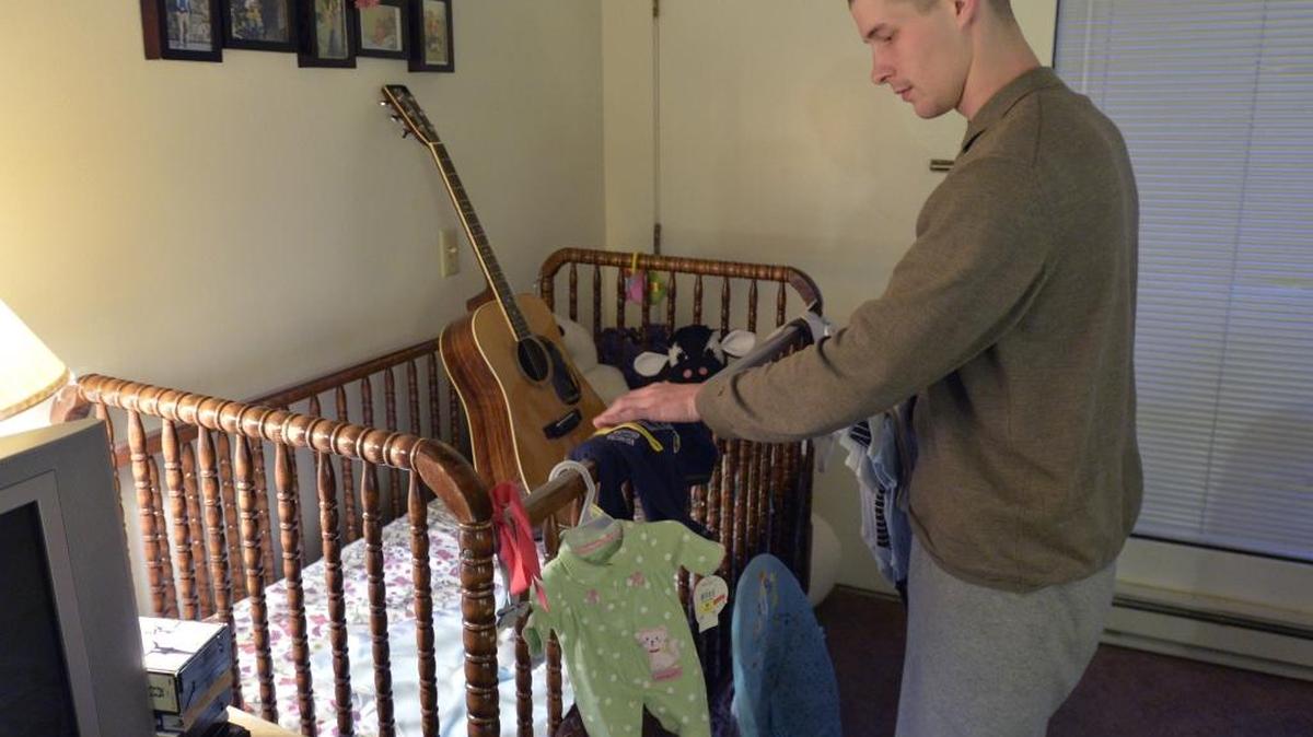 Cleve Goheen-Rengo looks at baby clothes for his three children in a Bellingham apartment, Dec. 2, 2014.
