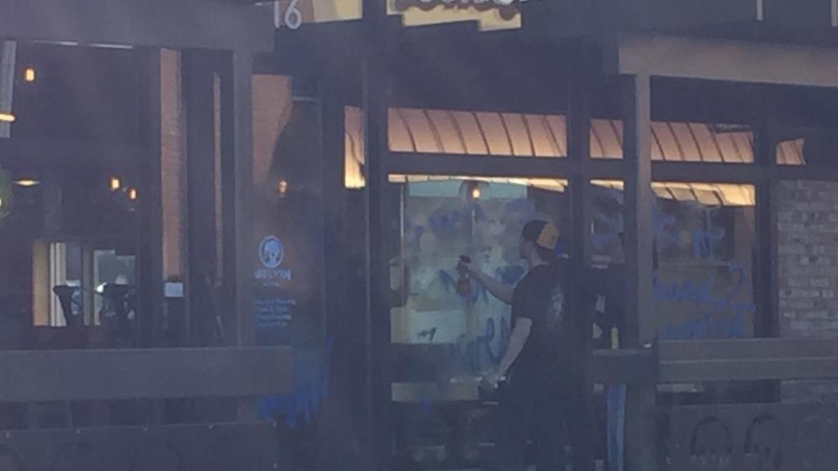 Melvin’s employees washed graffiti off the windows of the Meridian Street brewery Saturday morning.