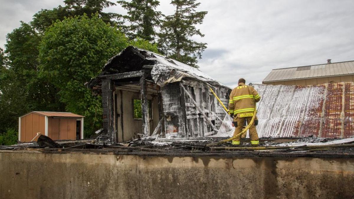 Lynden and North Whatcom firefighters spray down a shack that had caught fire Tuesday afternoon, May 24, 2016. A nearby burn pile ignited the building, which was being demolished at the time.