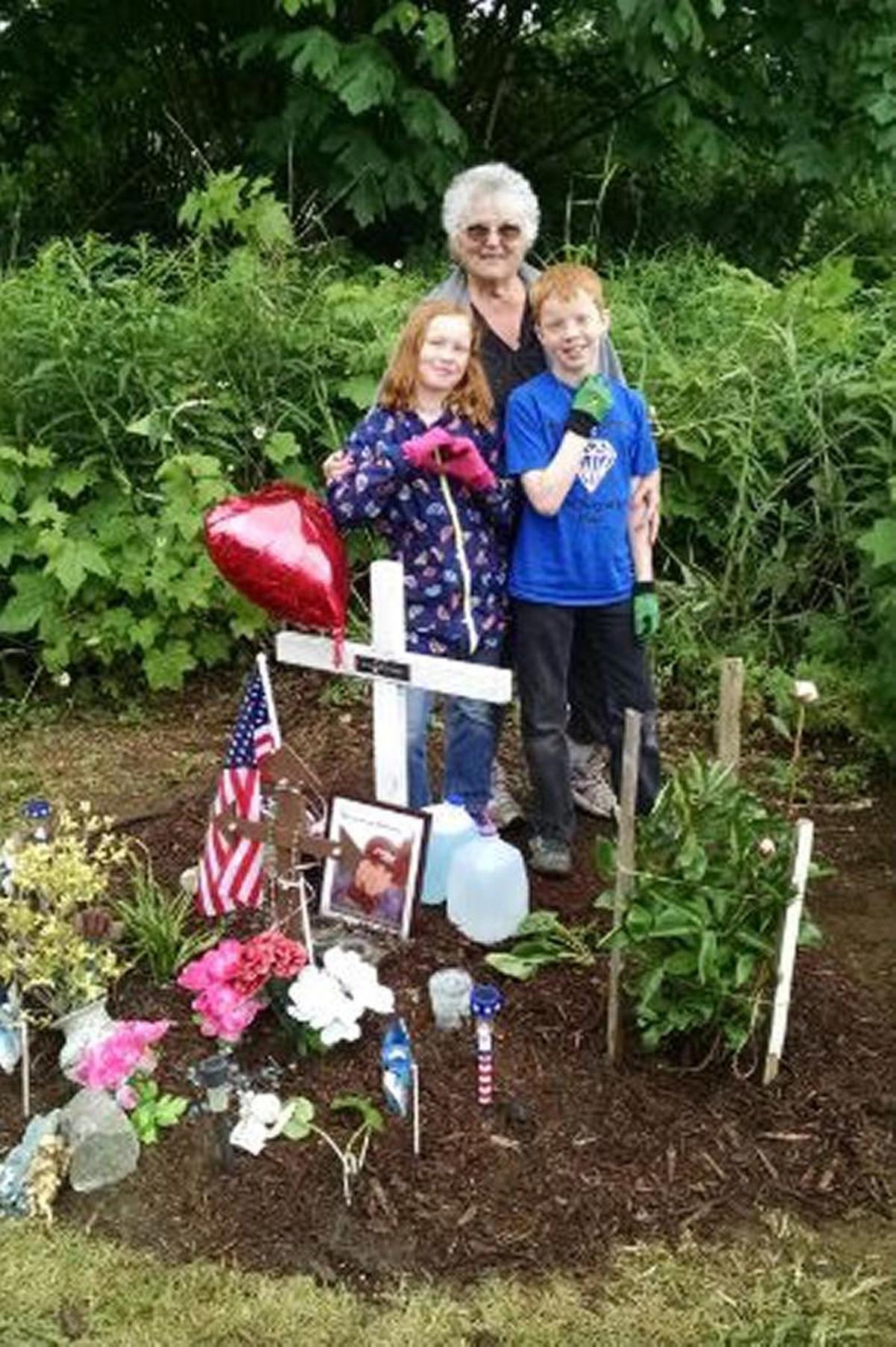JoAn Siden at the memorial that she maintains for her grandson Dominic Swope, who died May 30, 2014, in a motorcycle crash on East Pole Road. He was 32 years old. Siden is with Swope’s children, Lilli and Cooper.