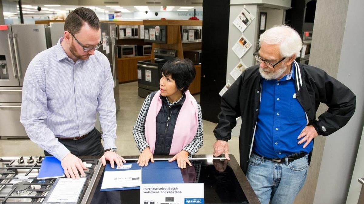 Rocio James, center, and David James, right, shop for appliances for a kitchen remodeling project with the help of sales associate Jason Bloomquist at DeWaard and Bode in 2016 in Bellingham.
