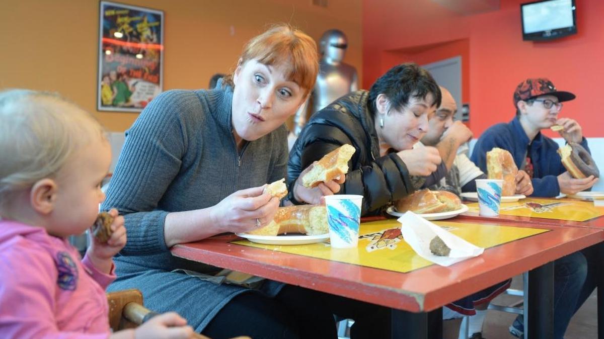 Sabine Sardeson, left, 16 months, watches as her mom Stephanie Sardeson, Heidi Oliver, Lenin Mendoza and Marshall Gibbins compete in a Monster Donut eating contest at Rocket Donuts in downtown Bellingham on Friday, Jan 15, 2016. Mendoza won, eating his 1-pound, 2-ounce doughnut in 6 minutes, 38 seconds.