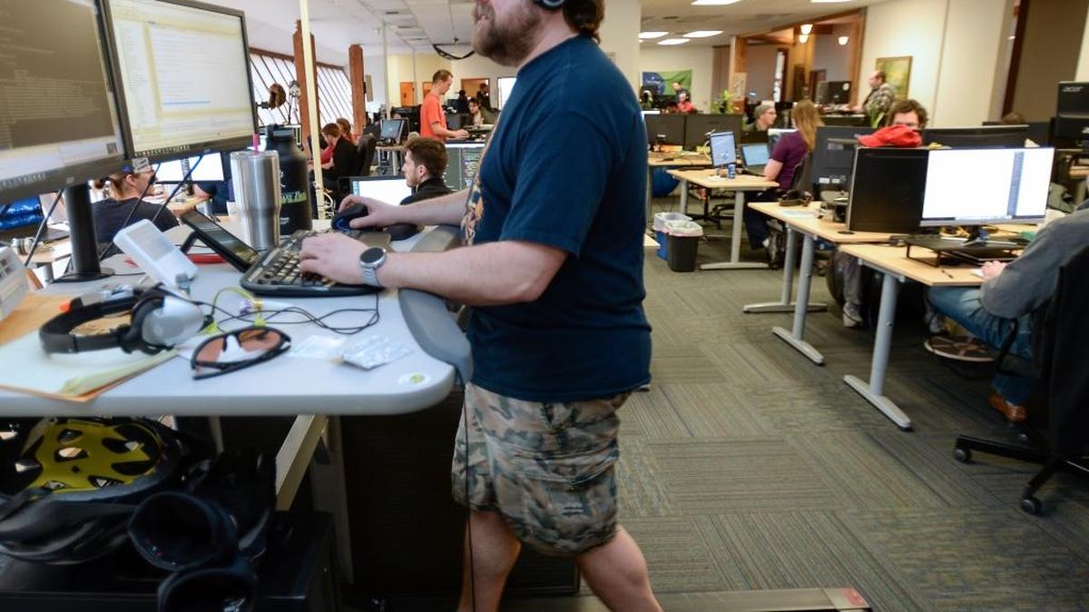 Software development engineer Justin Smith walks on a treadmill Thursday, March 9, 2017 while working at Conversica, a high-tech company in Bellingham that produces artificial intelligence bots that help sales people with contacts. Smith says he walks about 8-10 miles a day while working on the treadmill.