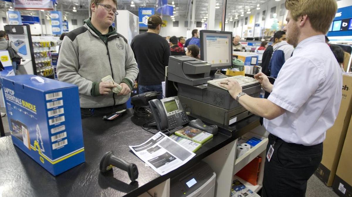 
Michael Reimer, from Langley, British Columbia, purchases a new laptop bundle from James Collins at Best Buy in Bellingham for the beginning of the holiday shopping season in 2013 in Bellingham. 
