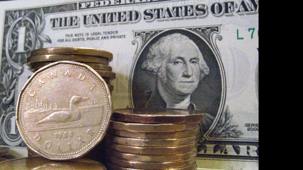 
Canadian dollar coins, also known as "loonies," are shown with a U.S dollar bill.
