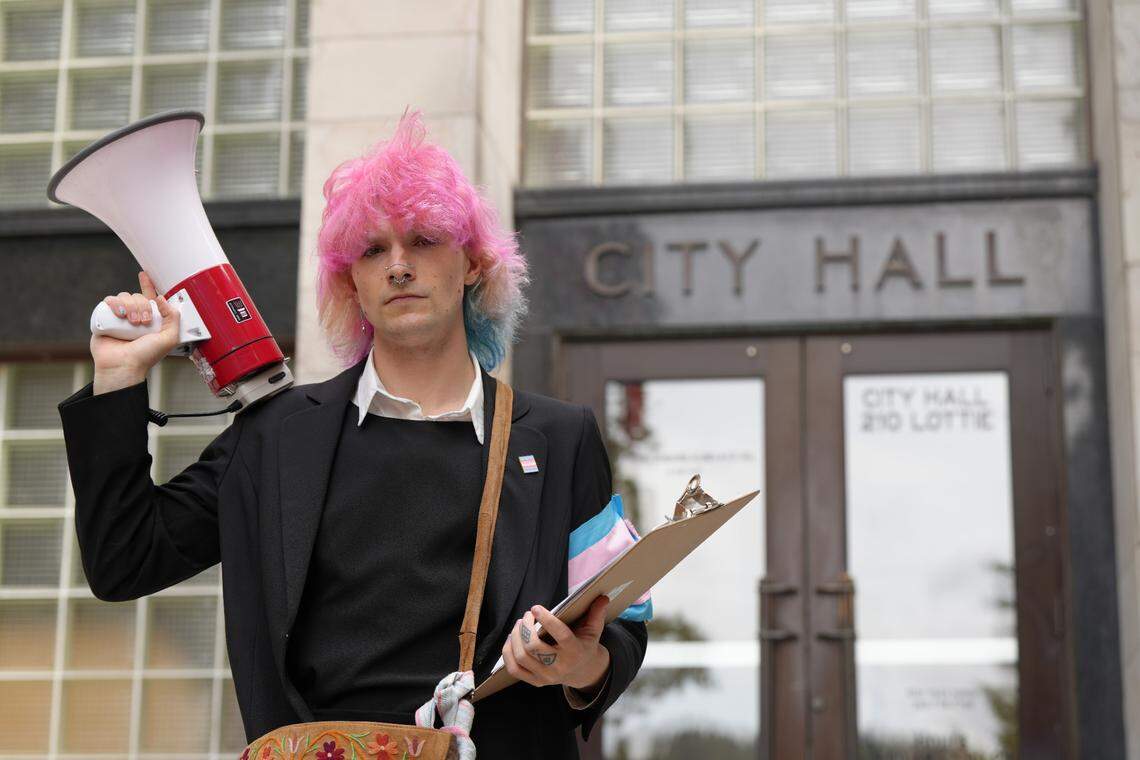 Transgender rights activist Selene Etheridge holds a megaphone and a clipboard in front of City Hall on June 4.