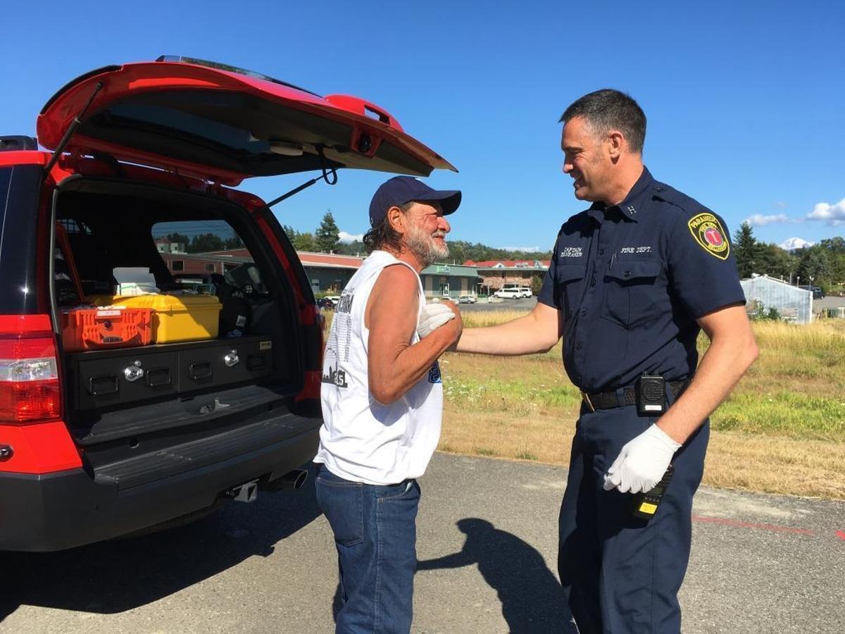 Carlos Abitia, left, greets Bellingham Fire Capt. Jeff Brubaker near a vacant lot that Abitia frequents and is often where he sleeps.