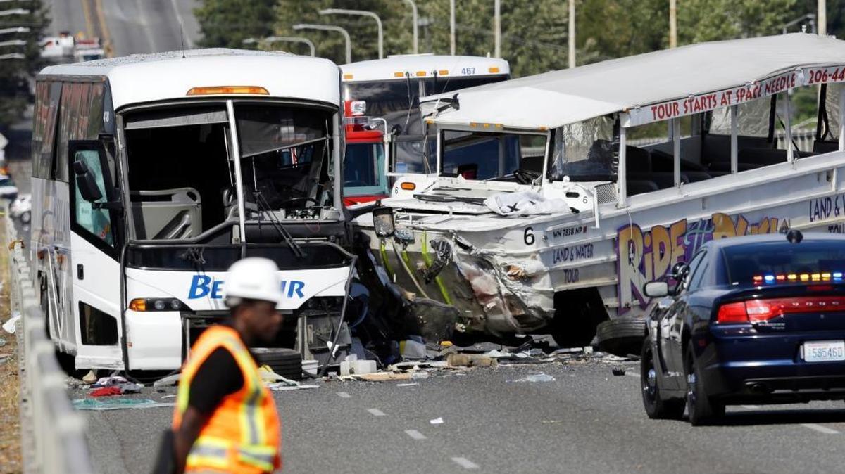 
An emergency official stands near a charter bus, left, and a “Ride the Ducks” amphibious tour bus that were involved in a fatal crash Thursday, Sept. 24, 2015, in Seattle.
