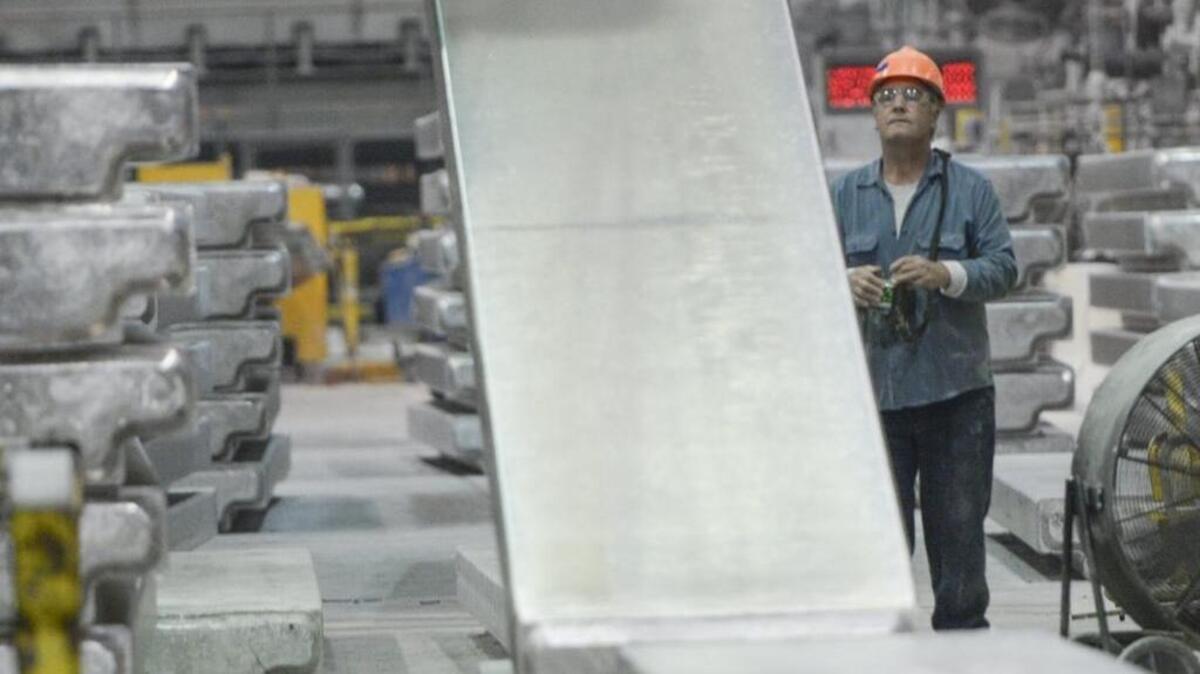 Casting specialist Ron Moa lifts a aluminum t-ingot at the Alcoa Intalco Works aluminum smelter west of Ferndale , Friday , Aug. 12, 2016.