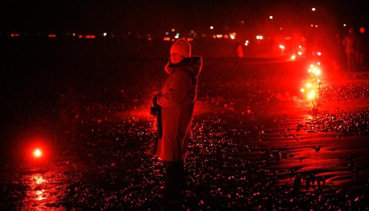 Pat Blackstad watches as flares burn along the beach at the annual Ring of Fire and Hope around Birch Bay in 2009.