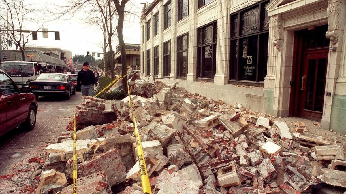 
In this Feb. 28, 2001, file photo, a passerby looks at the damage to the ornate facade that broke off from the Washington Federal Savings building at Capitol Way and 5th Avenue in Olympia, Wash., after a powerful earthquake hit the Northwest region. When North America’s undersea edge and a tectonic plate pushing beneath it inevitably give way to three centuries of accumulated stress, unleashing a monster earthquake and tsunami in the Pacific Northwest, the expected catastrophic loss of life and economic disruptions could be lessened by an early warning system.
