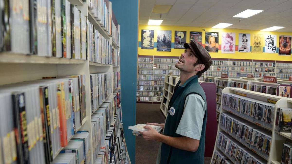 Chris Hazenberg stocks DVDs at Crazy Mike's Video in Bellingham. Friday, Oct. 14, 2016. The store is starting a closing business sale on Tuesday, Jan. 23.