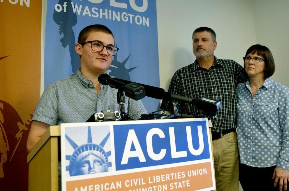 Paxton Enstad, left, addresses a 2017 news conference in Seattle about a lawsuit filed over refusal by an insurance plan to cover his gender-reassignment surgery as his parents, Cheryl and Mark Enstad, look on. The American Civil Liberties Union of Washington filed the discrimination lawsuit against PeaceHealth in federal court on behalf of Cheryl Enstad of Bellingham and her son.