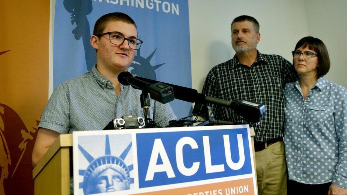 Paxton Enstad, left, addresses a news conference about a lawsuit filed over refusal by an insurance plan to cover his gender-reassignment surgery as his parents, Cheryl and Mark Enstad, look on Thursday, Oct. 5, 2017, in Seattle. The American Civil Liberties Union of Washington filed the discrimination lawsuit against PeaceHealth in federal court on behalf of Cheryl Enstad, of Bellingham, and her son. The lawsuit cites violations of the federal Affordable Care Act as well as Washington state anti-discrimination law.