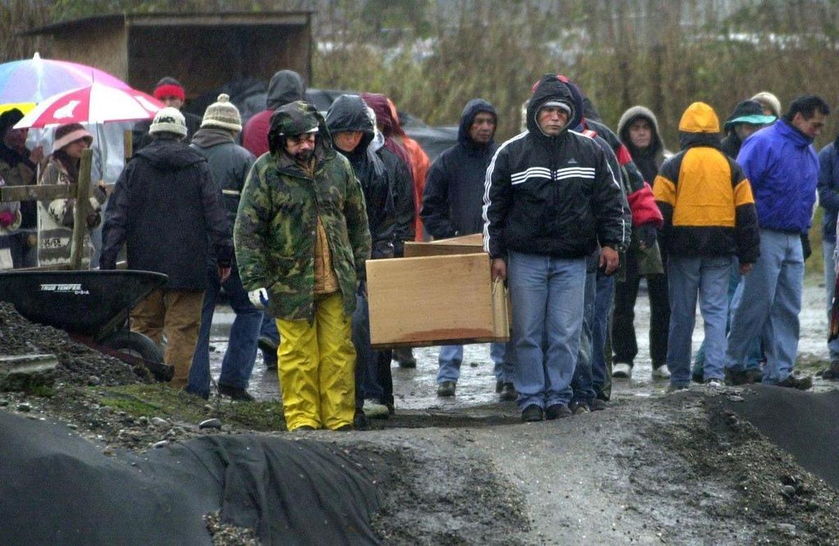 Pallbearers carry the remains of ancient natives down to a pit for reburial near a sewage treatment plant at Semiahmoo Spit on Dec. 10, 2001. The remains were dug up during an expansion project for the Blaine plant.