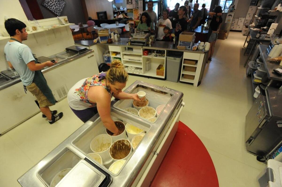 Ice cream maker Allison Constantin scoops out a bowlful of super chocolate ice cream while manager Scott Lew delivers a tasting sample at Mallard Ice Cream on Railroad Avenue in August 2011.