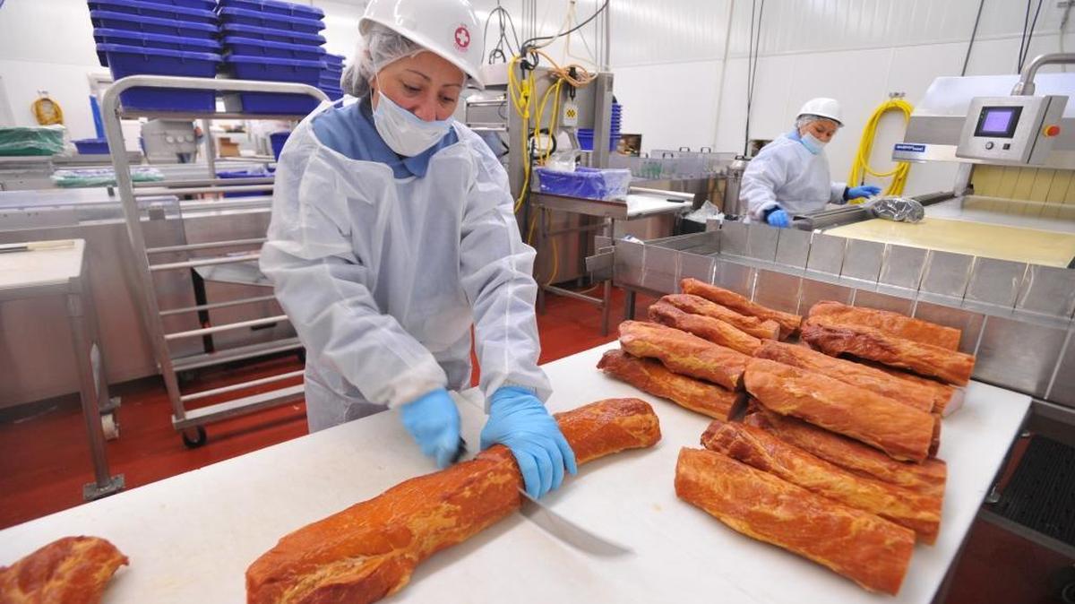 A worker in Washington state, not Canada, cuts Canadian bacon into 5-pound pieces to package the meat in 2011.