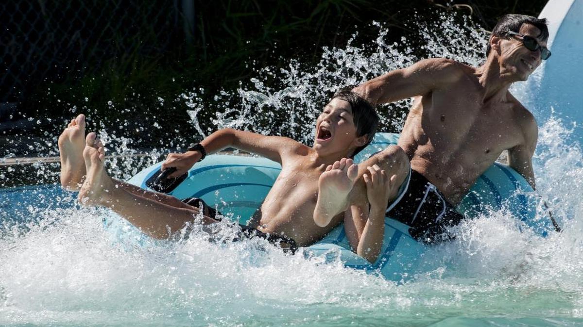 Adam Klausman, left, and his father, Jeffrey Klausman, splash into a pool at the bottom of The River Ride at Birch Bay Waterslides on Aug. 26, 2014, in Birch Bay. The water slides open for the 2016 season on June 4.
