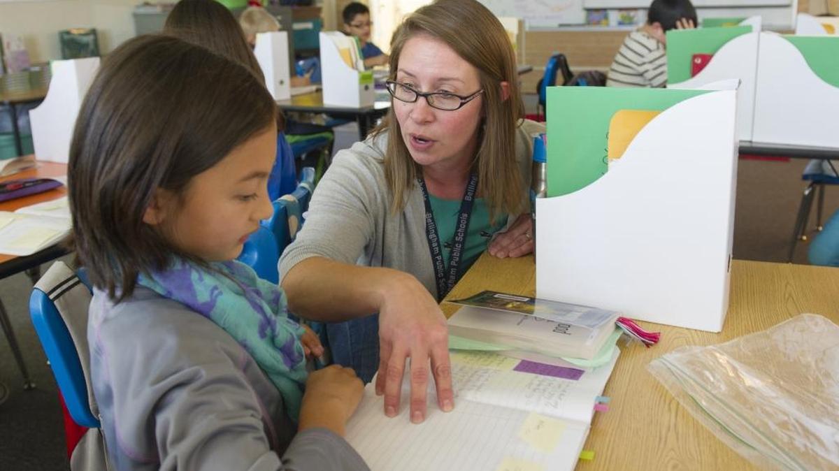 Parkview Elementary fourth-grade teacher Janelle Karney works with student Ami Purdue, 9, during a reading and writing class Sept. 30, 2015, at the Bellingham school. Bellingham is asking voters to renew two levies that make up more than 25 percent of the district’s budget.