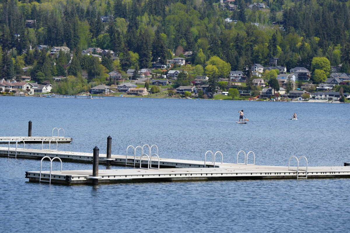 Paddleboarders recreate on Lake Whatcom beyond floating docks just off the shore of Bloedel Donovan Park on April 23, 2024, in Bellingham, Wash.