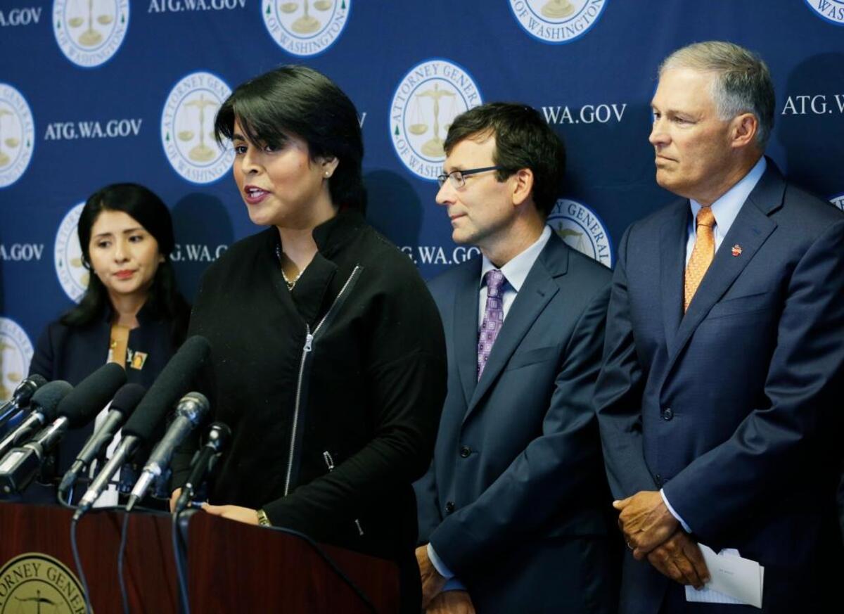 Monserrat Padilla, second from left, a participant in the Deferred Action for Childhood Arrivals, or DACA, program, talks to reporters, Wednesday, Sept. 6, 2017, in Seattle, as Washington Attorney General Bob Ferguson, second from right, and Gov. Jay Inslee, right, look on.