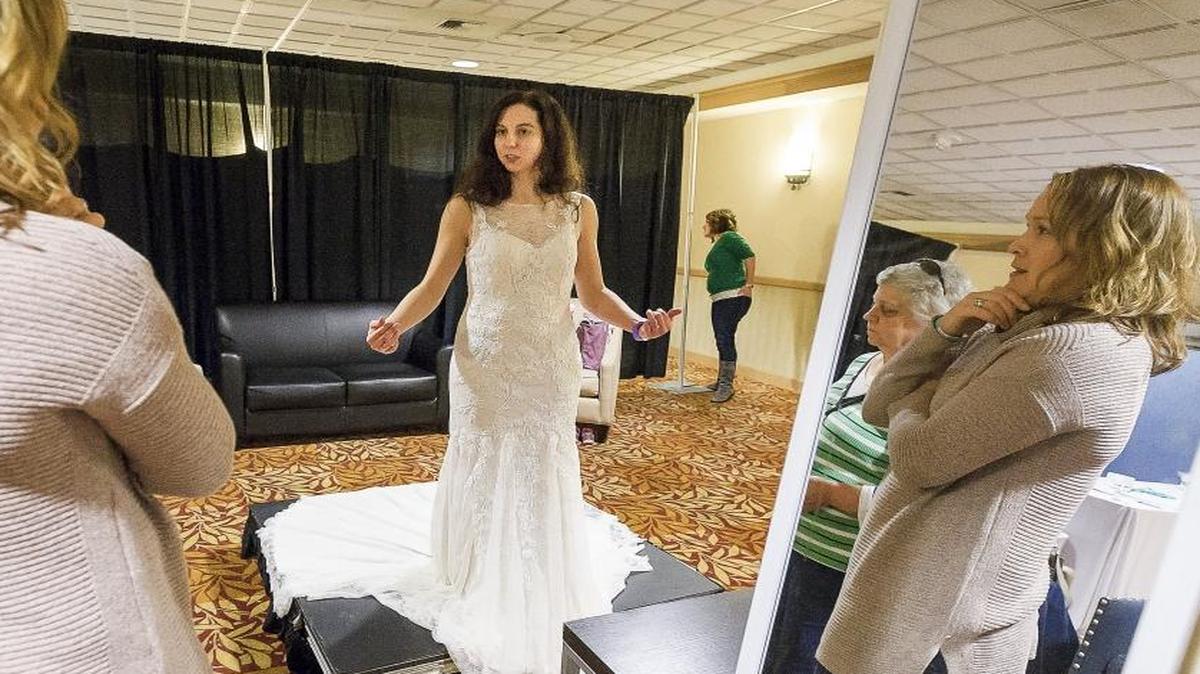 Rebekah Morgan of Glacier tries on a Justin Alexander wedding dress while seeking advice from her mother, Kathy Morgan, left, and friend Shawna McKay during the Bridal Inspirations Wedding Expo & Fashion Show, held January 2016 at Four Points By Sheraton Bellingham Hotel & Conference Center. The 2017 expo will be Jan. 21, also at Four Points.