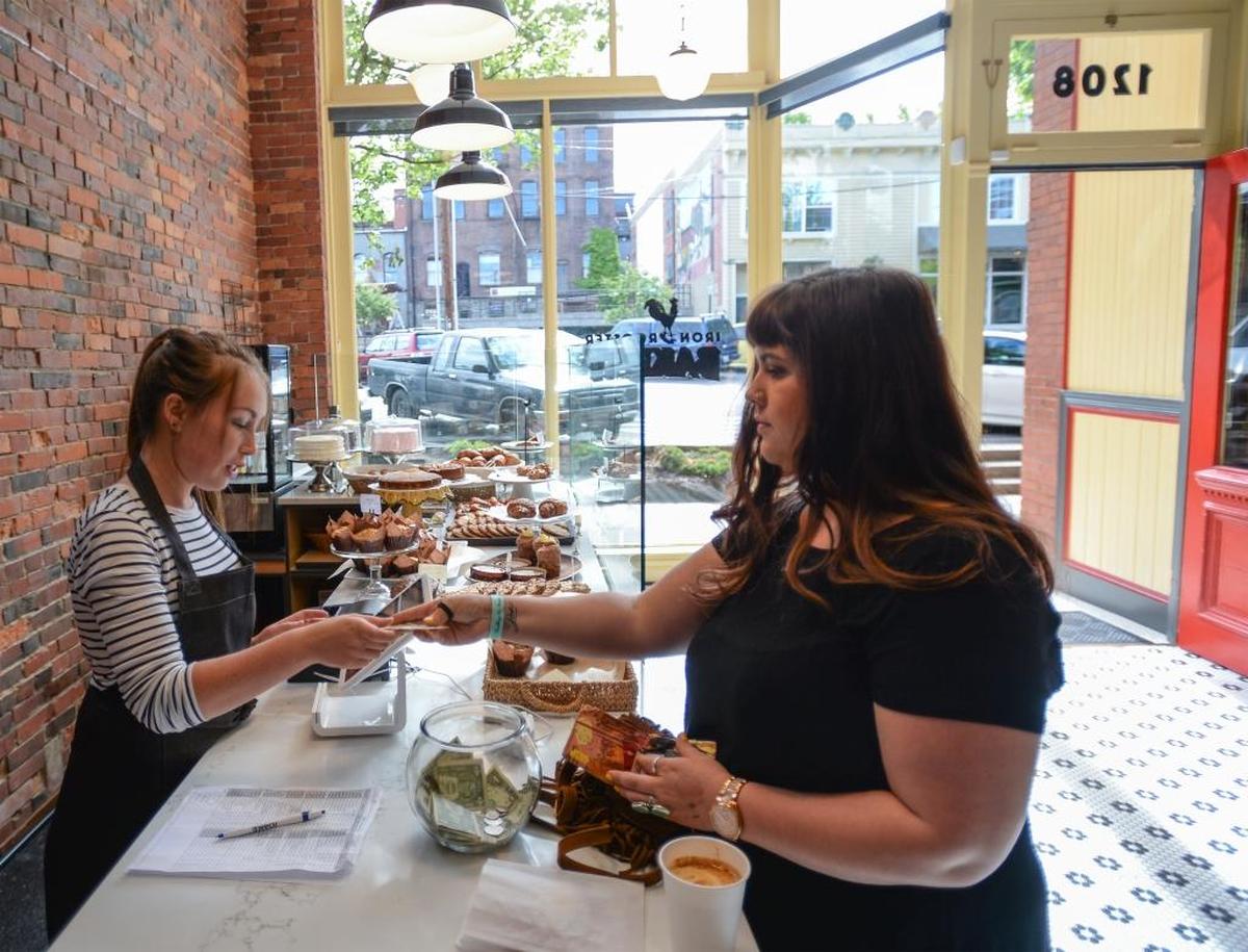 Molly Rowley, left, fills customer Sam Pence's order at Iron Rooster Bakery in the Fairhaven District of Bellingham, Friday, June 9, 2017.