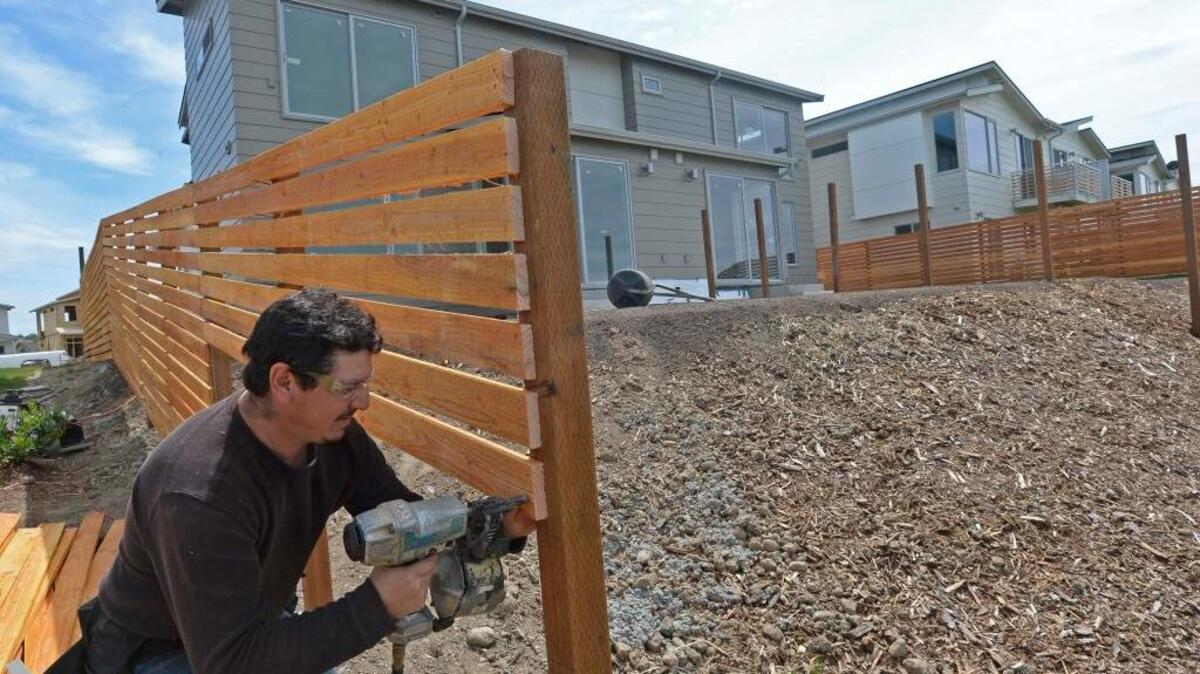 Octavio Valles of Heron Point Construction builds a fence at the Spring Vista townhouse development in north Bellingham on Wednesday, June 1, 2016. Of the 42 units, 33 have sales pending.