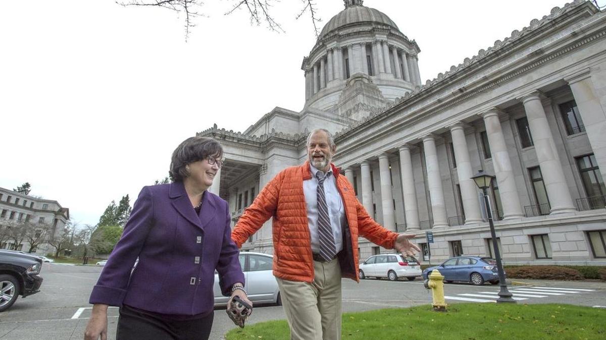 Rep. Hans Dunshee chats with Rep. Kris Lytton - chair of the House Finance Committee - as they walk across the Capitol Campus to a lunch meeting in Olympia on Nov. 18, 2015.