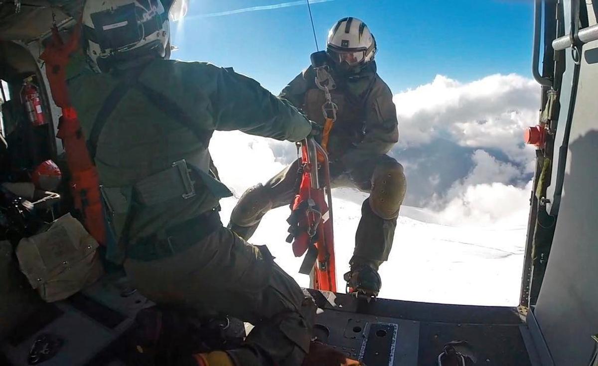 A member of a search and rescue helicopter crew from Whidbey Island Naval Air Station prepares to be lowered down to rescue an injured climber from the 9,000-foot level of Mount Baker on Sunday afternoon.