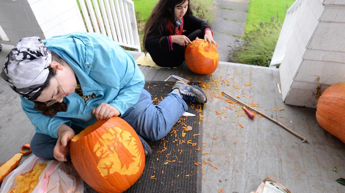 Julia Stark, left, and her sister Nina Stark carve pumpkins Wednesday, Oct. 26, 2016, a in Bellingham. Watch her explain her technique in a video at bellinghamherald.com.