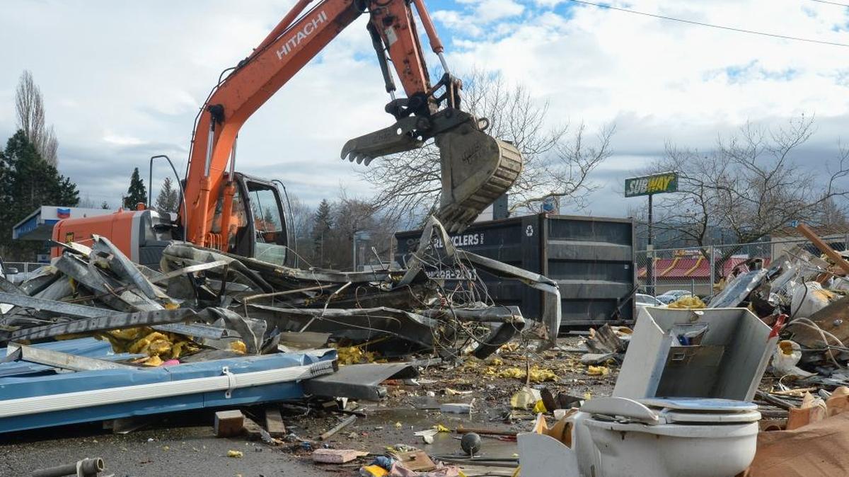 An excavator from J.T. Muenscher Construction separates demolition debris after taking down the Jalopy Jakoozee Car Wash on the corner of Iowa and King Streets in Bellingham on Wednesday Feb. 10, 2016. A Starbucks drive-thru should be up and running on the site by summer.