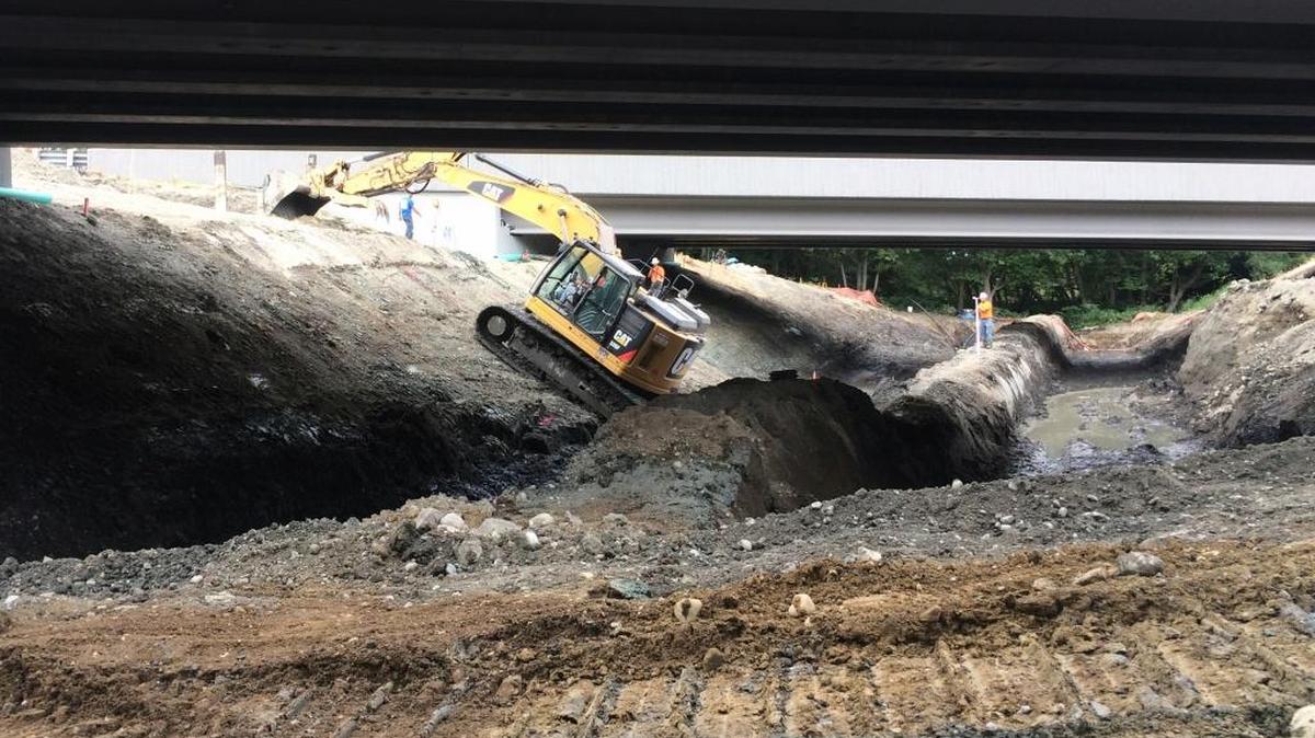 Beneath the twin Interstate 5 bridges recently completed south of Conway, Washington, crews are preparing to remove a culvert that has restricted the flow of Fisher Creek since about 1970.