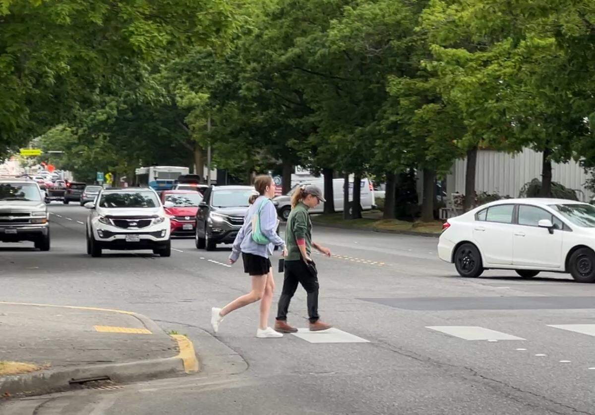 Traffic stops as people cross James Street at Carolina Street in a crosswalk with flashing yellow lights on June 12, 2025, in Bellingham, Wash.