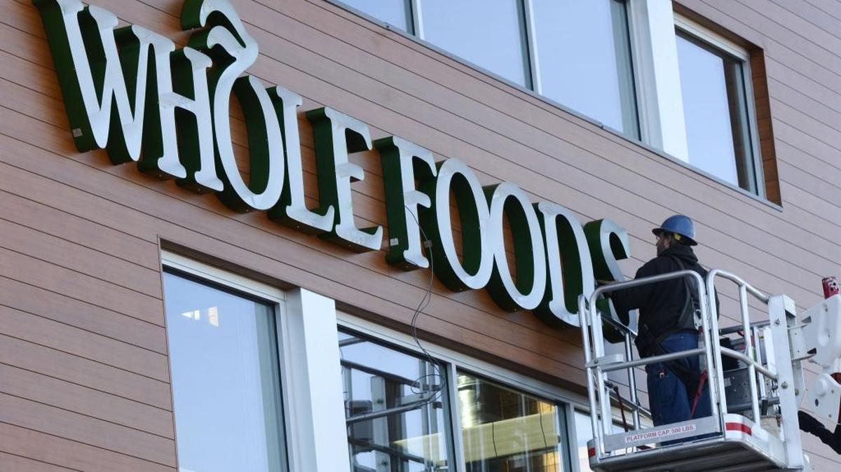 Steve Bates of Signs Plus puts up a new sign on the Whole Foods grocery store in the Lakeway Center in Bellingham Thursday, March 31, 2016. The store is scheduled to open May 11.