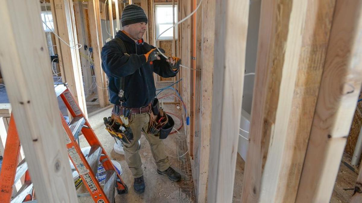 Express Electric electrician Tony Veliz wires a new house under construction at the Trio at Cordata housing project off June Street in the Cordata neighborhood of Bellingham, Wednesday, Jan. 3, 2018. Sixty-nine houses are scheduled to be built.