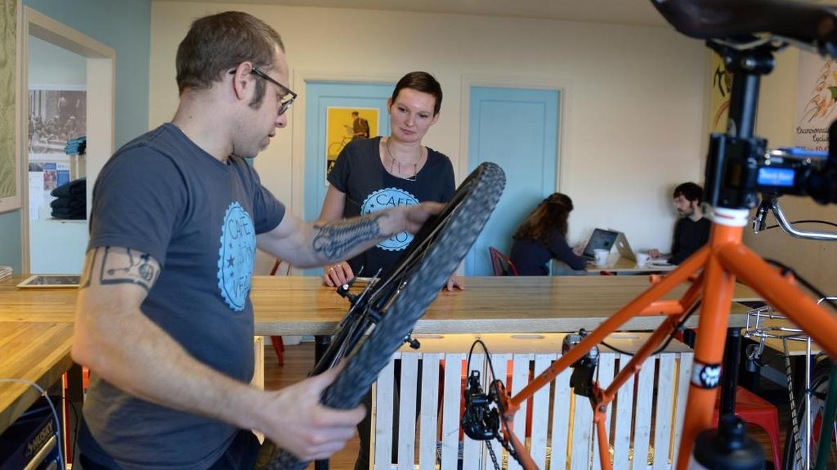 Andrew Francis works on a bike while his wife Kim Strang looks on at their new business Cafe Velo in downtown Bellingham Thursday, Jan. 12, 2017. Cafe Velo serves espresso, food, beer and bike repairs. It’s one of the few businesses that have opened in early 2017.