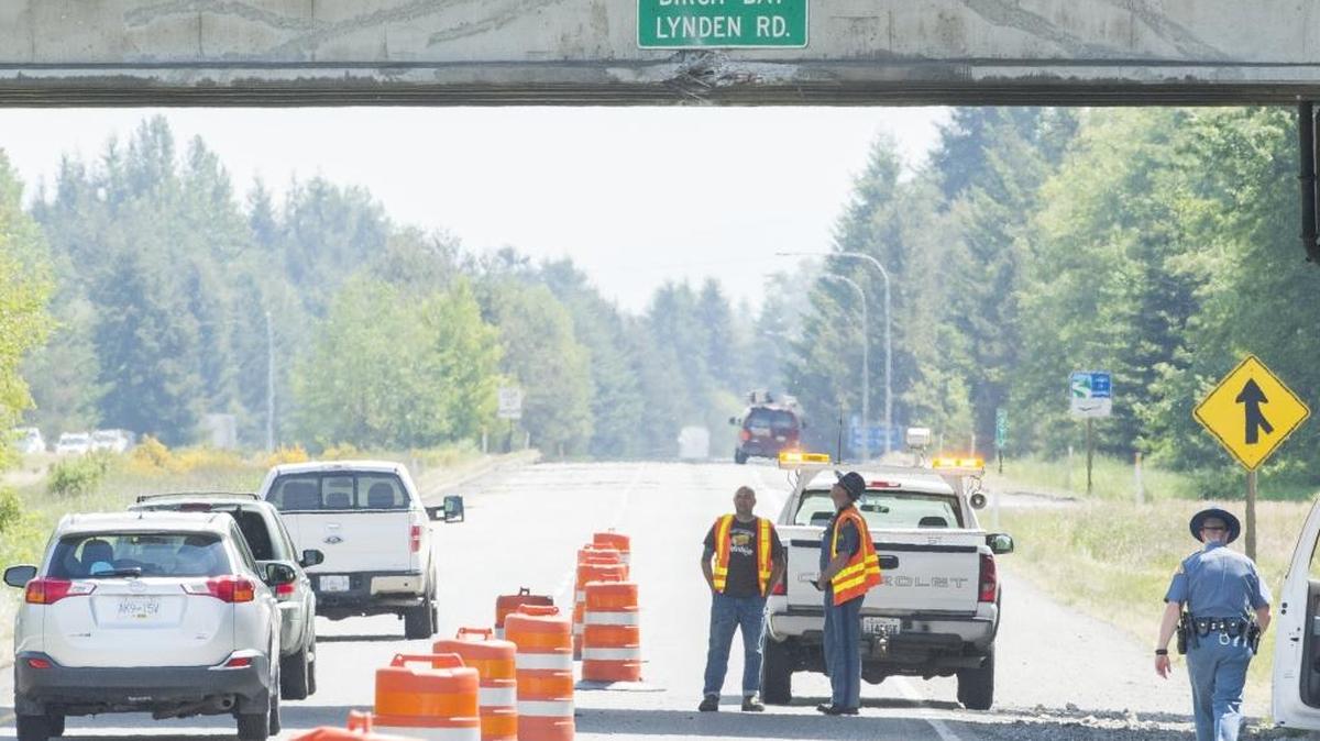 Officials assess damage to the Birch Bay-Lynden Road overpass on the southbound side of Interstate 5 on May 21, 2015. The southbound lanes of I-5 directly beneath the overpass will be closed for several hours early Friday, April 15.