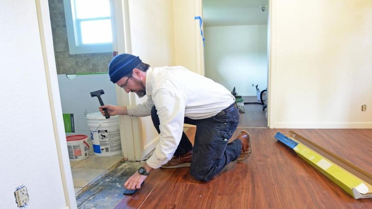 Lydia Place facilities manager Chris Ludjin installs a floor Feb. 23, 2016, in one of the apartments Domestic Violence & Sexual Assault Services of Whatcom County and Lydia Place have teamed up to acquire to house homeless women and abused women in Bellingham.