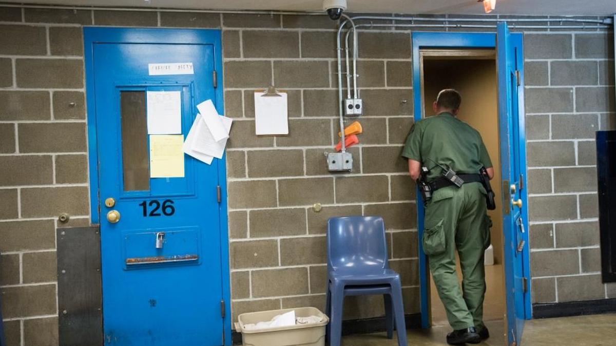 A deputy speaks to an inmate in a first-floor holding cell at Whatcom County Jail in Bellingham in this June 28, 2015 file photo.