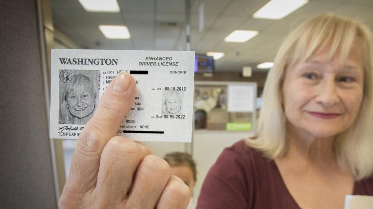 Michelle Henrick shows off a temporary enhanced drivers license she just received at the state licensing office in Tacoma on Tuesday, Aug. 16, 2016. A pen was used to black out sensitive information.
