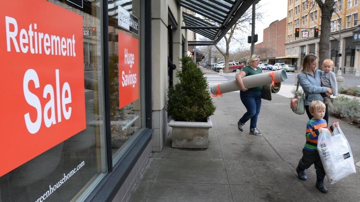 Greenhouse employee Jen Costaldo carries rugs that customer Robin Sheehy purchased during the retirement sale at the downtown Bellingham store, Nov. 13, 2017. Sheehy’s children Patrick Sheehy, 3, and Noah Sheehy, 18 months, also are pictured.