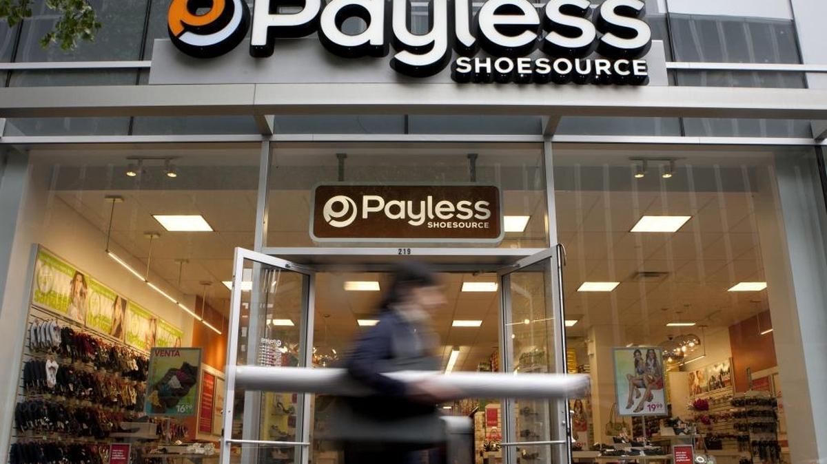 A pedestrian passes in front of a Payless ShoeSource Inc. store in New York on May 2, 2012.