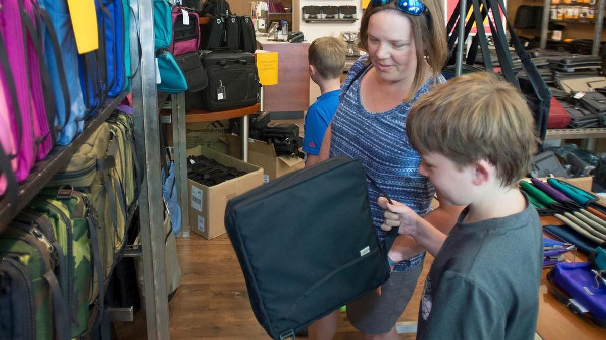 
Evan Auld, 9, left, his mom Susan Auld, and brother Kellen Auld, 11, shop for binders at the Brenthaven retail store in Fairhaven on Tuesday, August 4, 2015. The store is closing for good on Labor Day, though Brenthaven will keep its Seattle store and online shopping site.
